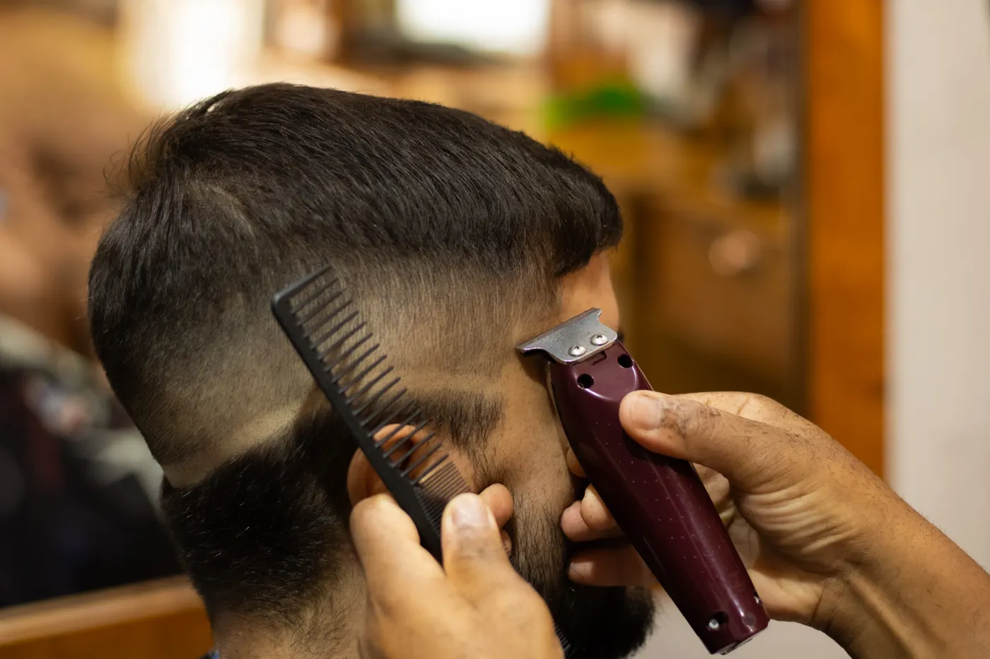 Coiffeur qui travaille à la tondeuse et au peigne